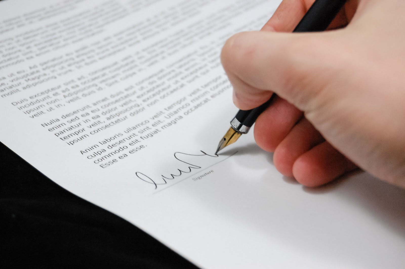 Hand signing a legal document.
