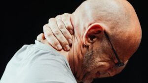 A man holding his neck in pain.